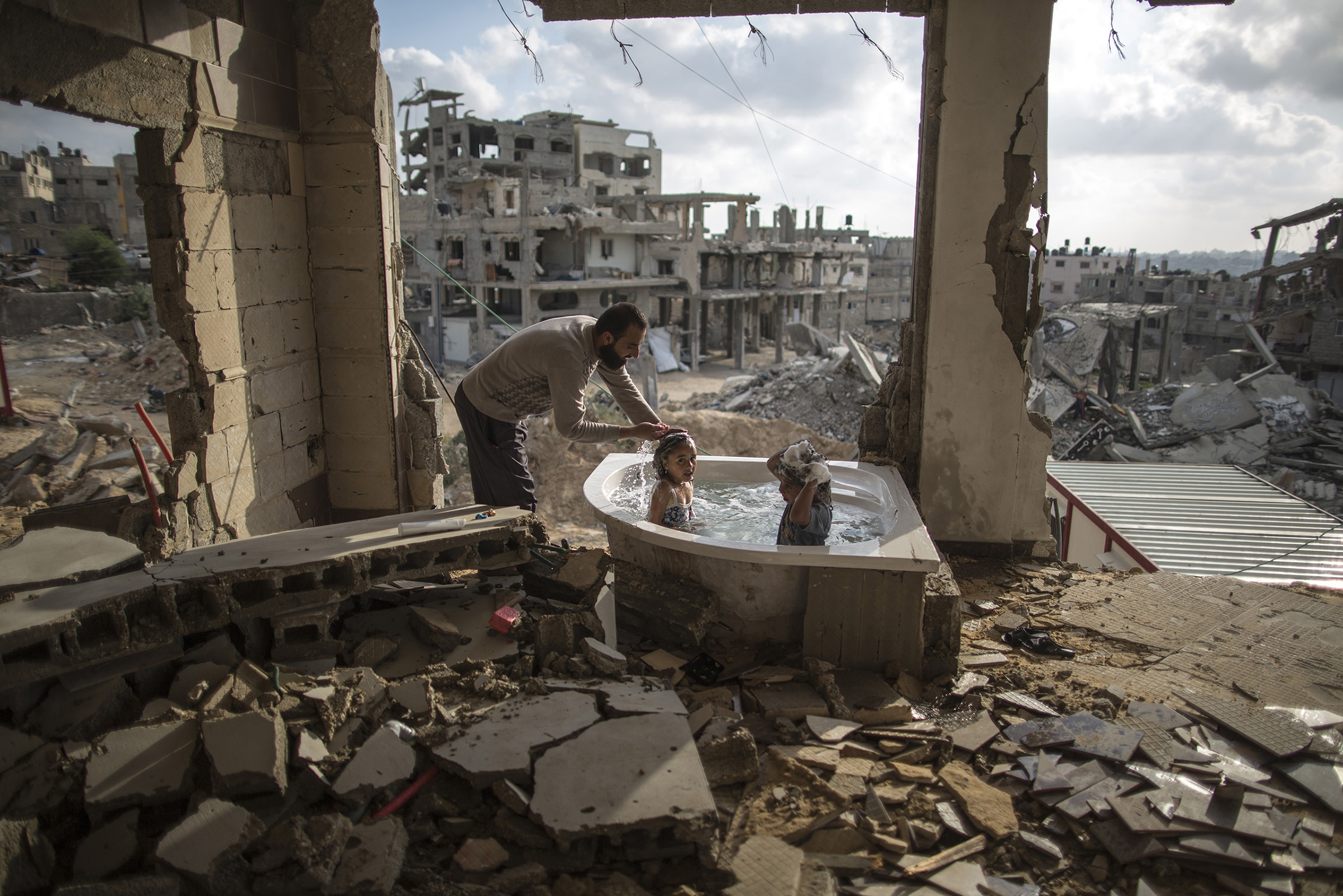 June 26, 2015  .Salem Saoody, 30, is getting his daughter Layan (L) and his niece Shaymaa 5 (R) in the only remaining piece from their damaged house, which is the bathing tub. They now live in a caravan near the rubbles. By Wissam Nassar.