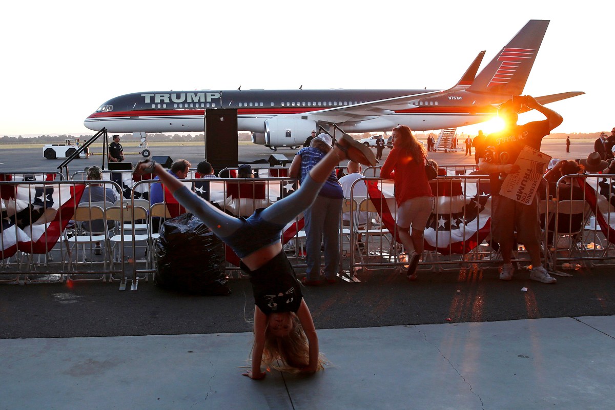 Rylee Jacobs, 10, does cartwheels in front of the plane of U.S. Republican presidential candidate Donald Trump after Trump spoke at a campaign rally in Sacramento