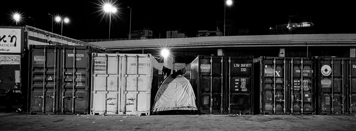 A tent sits among containers at the Greek port of Piraeus, near where refugees and migrants live in a temporary camp.
