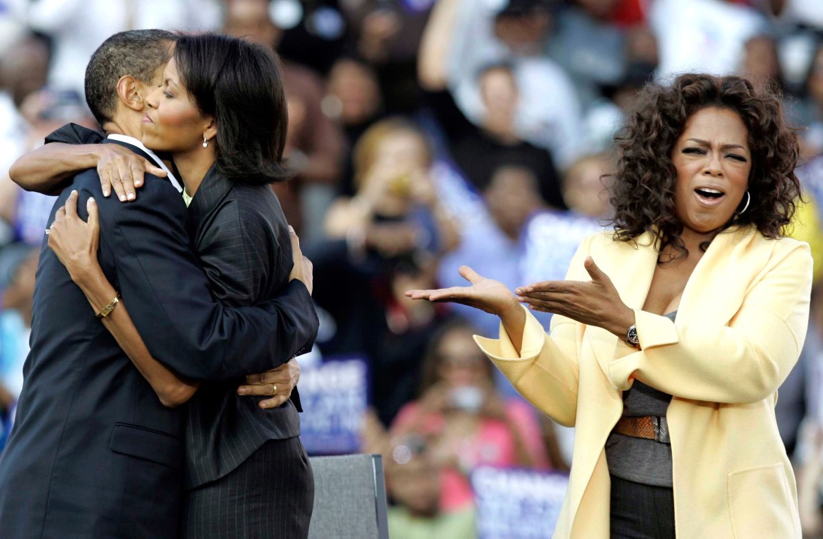 Barack Obama and Michelle Obama embrace as Oprah Winfrey campaigns with them during a rally at Williams Brice Stadium in Columbia, S.C., Dec. 9, 2008.