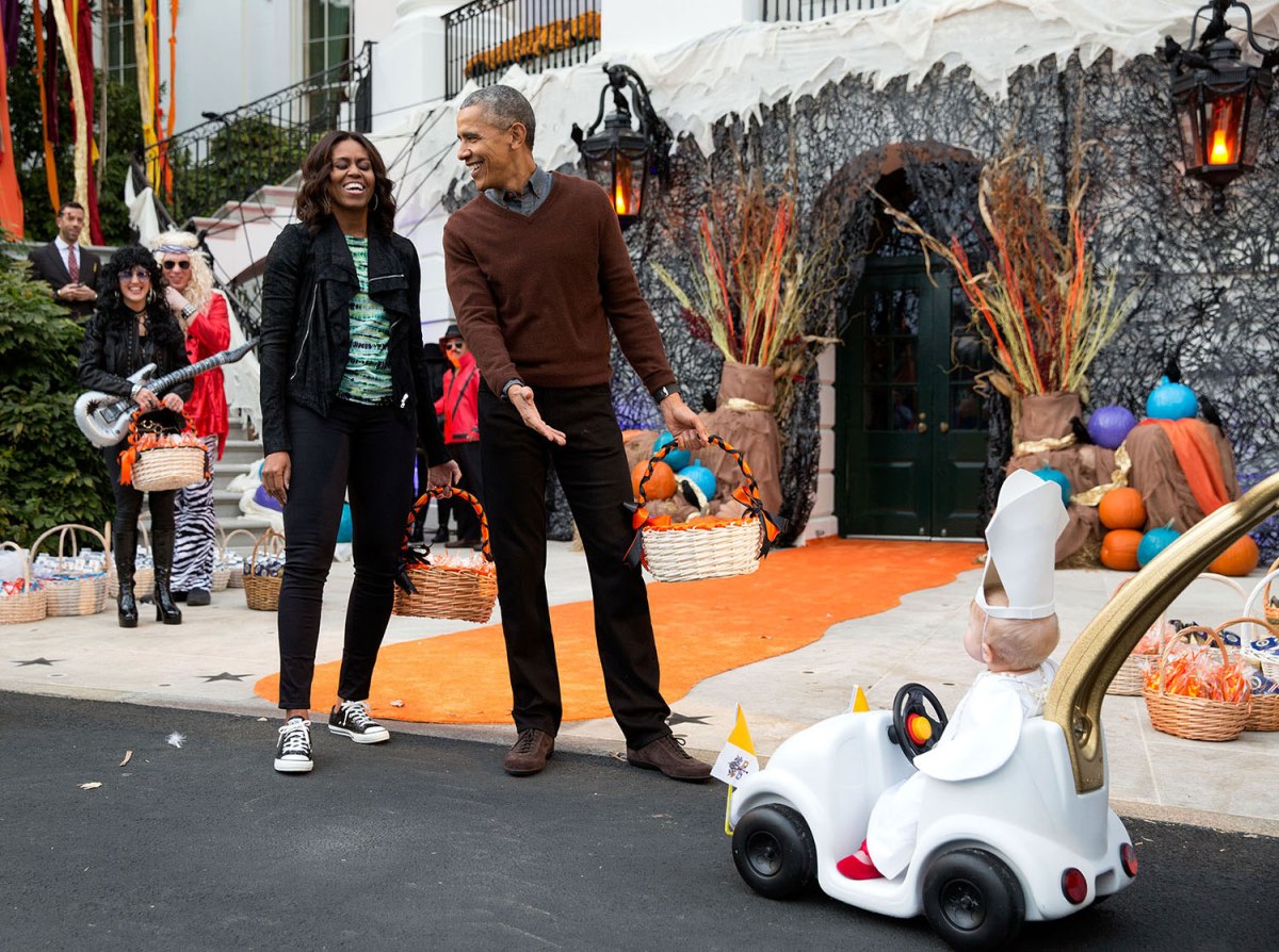The President and First Lady react to a child in a pope costume and mini popemobile as they welcomed children during a Halloween event on the South Lawn of the White House in Washington, D.C., Oct. 30, 2015.