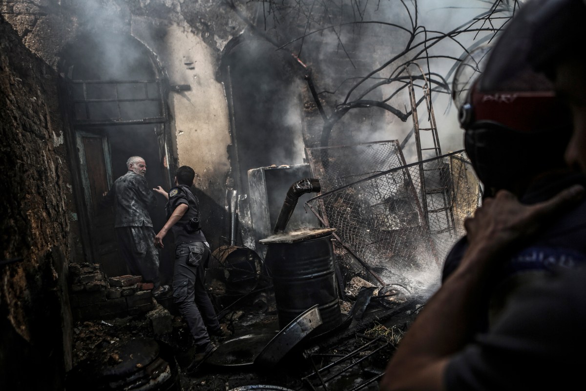 First-responders attempt to stop Abu Soubhi from entering his home following an airstrike in the rebel-held area of Douma, on the outskirts of Damascus, on Sept. 11, 2016.