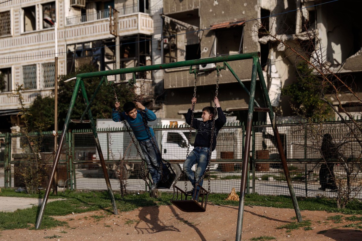 Boys play on a swing set during a halt in fighting in Douma, in the region of Eastern Ghouta outside Damascus, on Feb. 27, 2016.