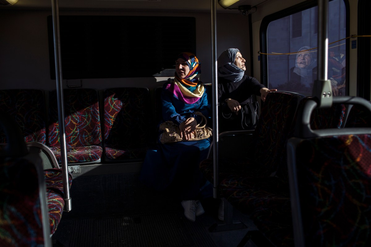 Ghazweh and her friend, Mumena El Ali, ride the bus while on their way to ESL class at a community college.