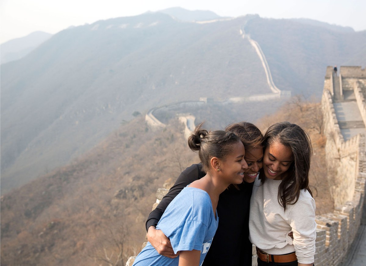 In this official White House photograph, First Lady Michelle Obama hugs daughters Sasha, left, and Malia as they visit the Great Wall of China in Mutianyu, China, March 23, 2014.