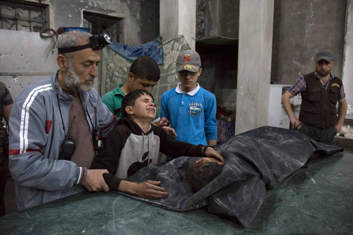 A Syrian boy is comforted as he cries next to the body of a relative who died in a reported airstrike in a rebel-held neighborhood of Aleppo on April 27, 2016.
