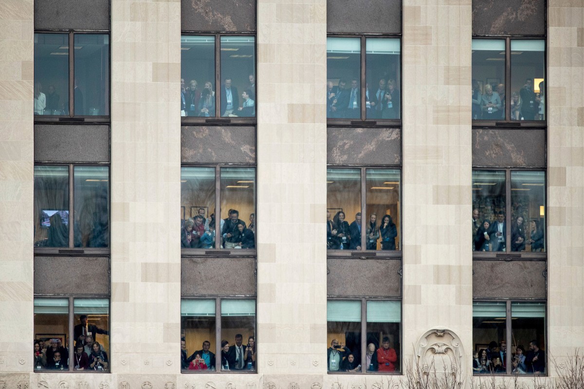 People crowd windows in a building on 15th Street and Pennsylvania Avenue while waiting for President Trump during the inaugural parade in Washington, D.C., on Jan. 20, 2017.