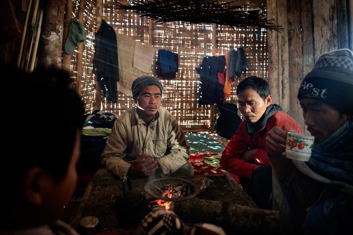 Hkawng Lum, second from right, a miner and heroin addict from Hpakant who worked in the mines for 10 years, warms himself by the fire at a rehabilitation facility near Myitkyina.