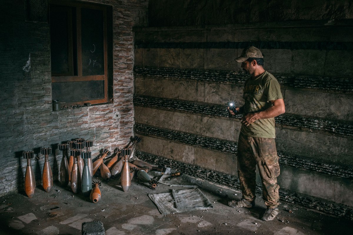 A member of the Iraqi special forces' Rapid Response Brigade looks at mortars manufactured by ISIS inside a house in the al-Aqeedat district in southwest Mosul on March 29.