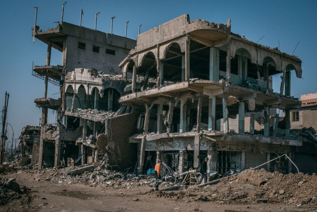 Civilians walk on a street in the Dawasa neighborhood of southwest Mosul on March 30.