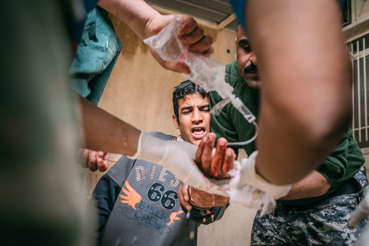 Karim Jassem Mohammed, 19, who was shot in the hand by an ISIS sniper while he was queuing for bread in the Mosul Al-Jadida district of southwest Mosul, is treated at a field hospital on March 31.