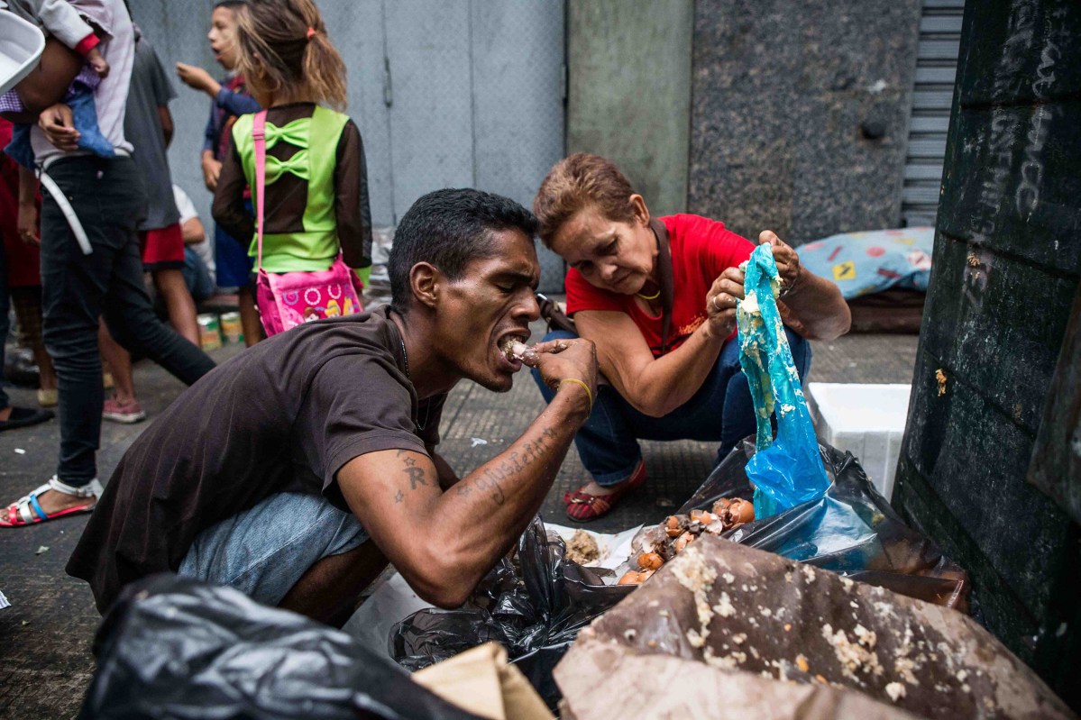 A man eats bits of food found in trash in Caracas in September 2016. Cristian Hernández—Climax