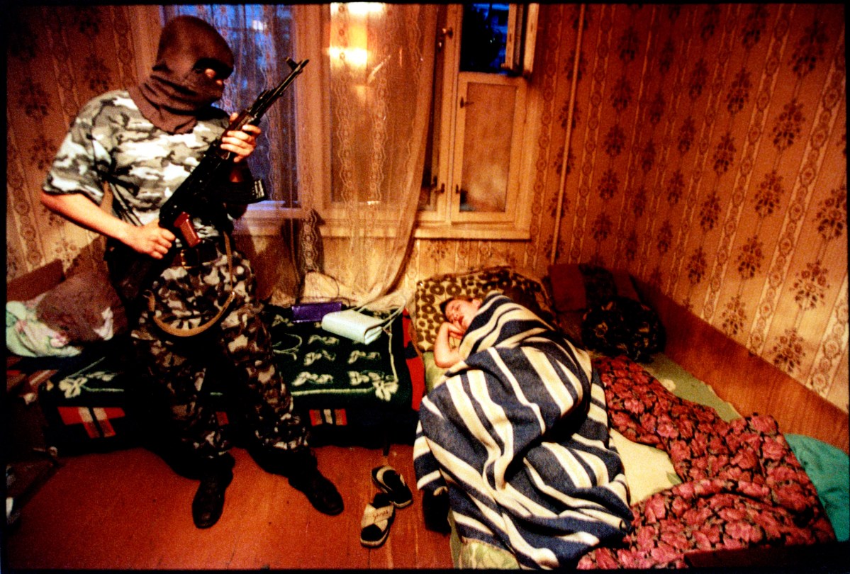 Putin's Russia - The Darkness of Russia June 2001 Volgograd, Russia Drug raid, the OMON squad is a special purpose police unit, militia-comando outfit. They wear military style uniforms and sometimes masks, blue flak jackets and carry machine pistols, AK-47's. Stanley Greene—NOOR