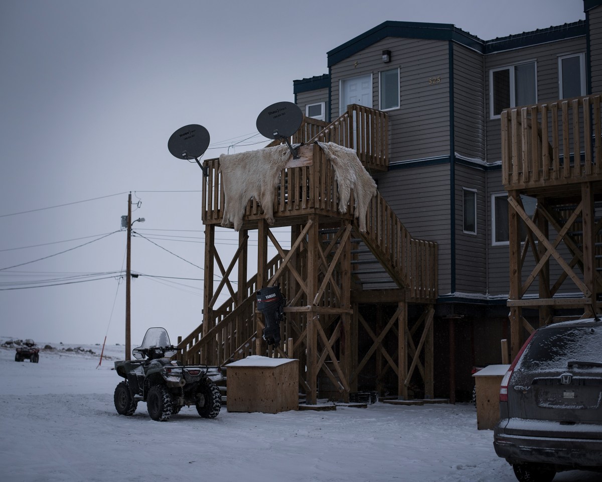Polar bear pelts hang outside to dry. In the 1960s the Canadian government encouraged the traditionally nomadic Inuit to move into subsidized housing.