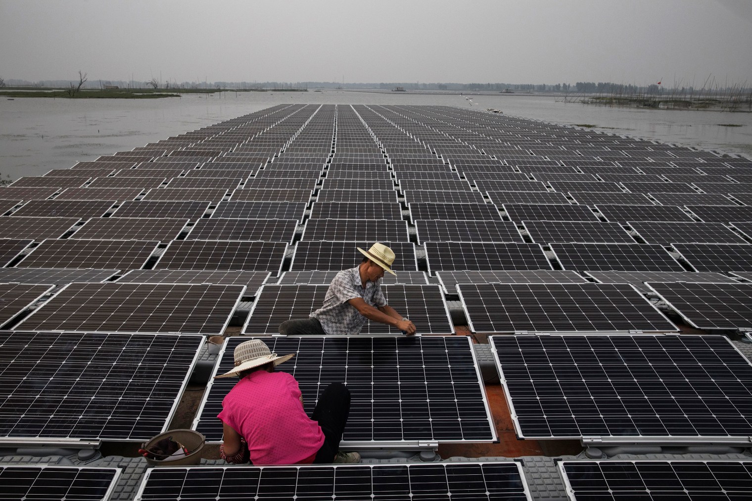 Workers prepare panels that will be part of a large floating solar farm project.