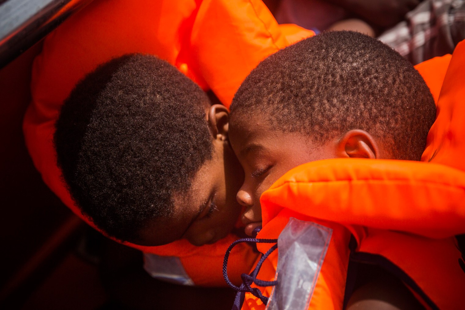 Two children sit in life jackets during their rescue.
