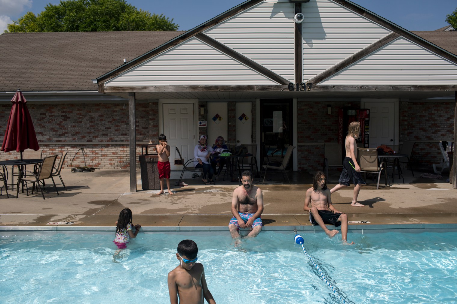 Abdul Fattah Tameem and his family enjoy the pool on a hot summer day at the family's new apartment complex in West Des Moines, a suburb of Des Moines, Iowa.