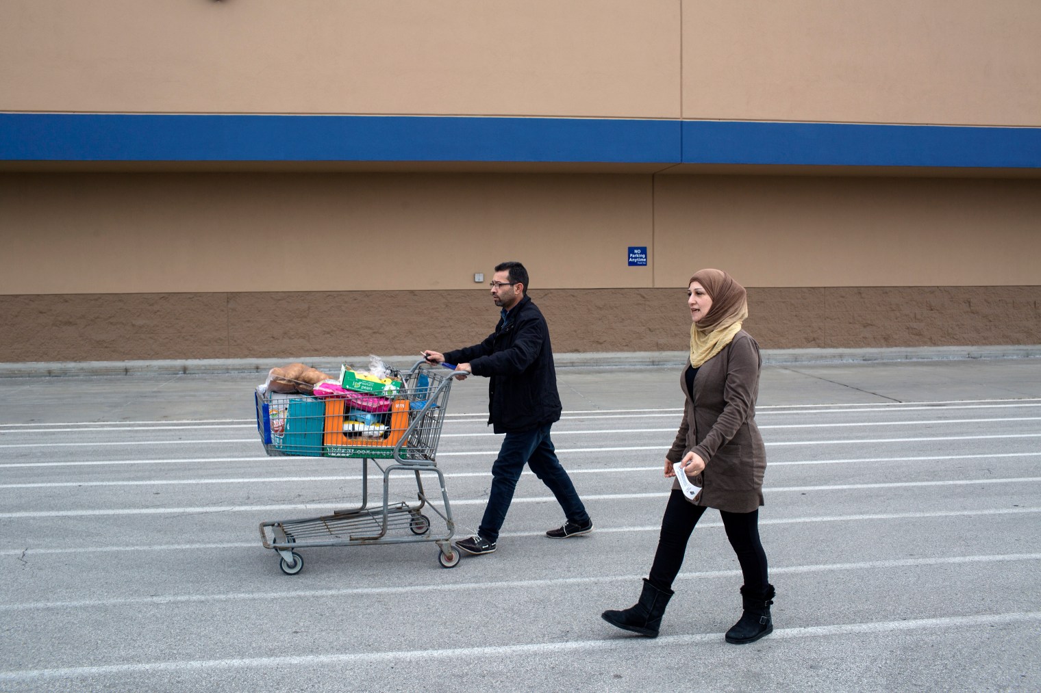 Abdul Fattah Tameem and his wife, Ghazweh Aljabooli, leave the store after shopping for their family. The parents of five moved their family to West Des Moines, a suburb of Des Moines, Iowa.