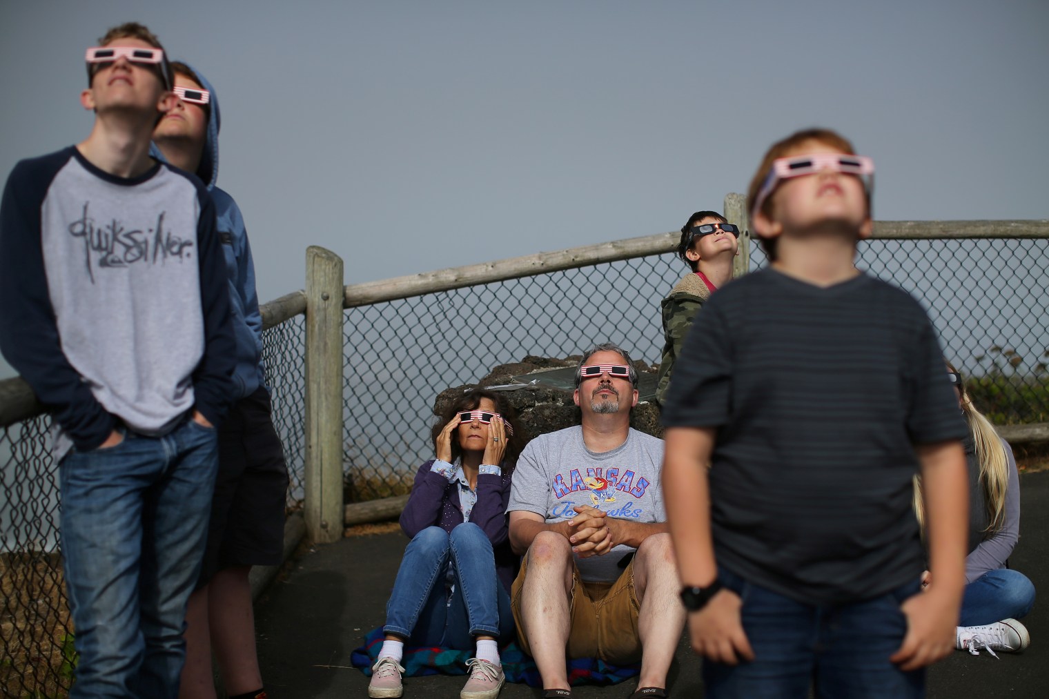 A boy uses solar viewing glasses as the sun emerges through fog cover before the solar eclipse in Depoe Bay, Oregon on Aug. 21, 2017.