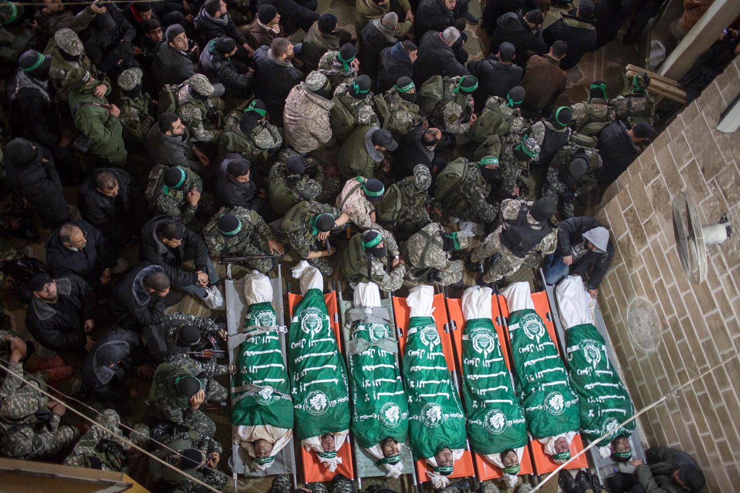 Palestinian fighters of the Izz Al-Din al-Qassam brigades, the military wing of Palestinian Hamas organization, sit around the bodies of seven fighters in Al Omari mosque during their funeral in Gaza City on January 29, 2016. Seven fighters from were killed after a tunnel built in the conflict with Israel collapsed.