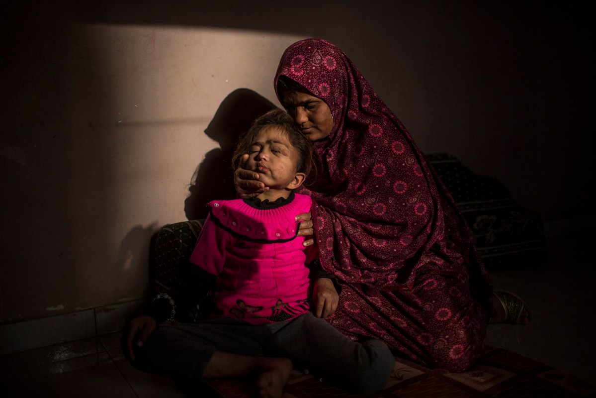 Samah, while hugging her 8-year old Daughter Enshirah, who is suffering from Brain Cancer and living in very bad economic circumstances. Samah hopes that Enshirah recovers and become able to go to school. Beit Hanoun, Gaza Strip.