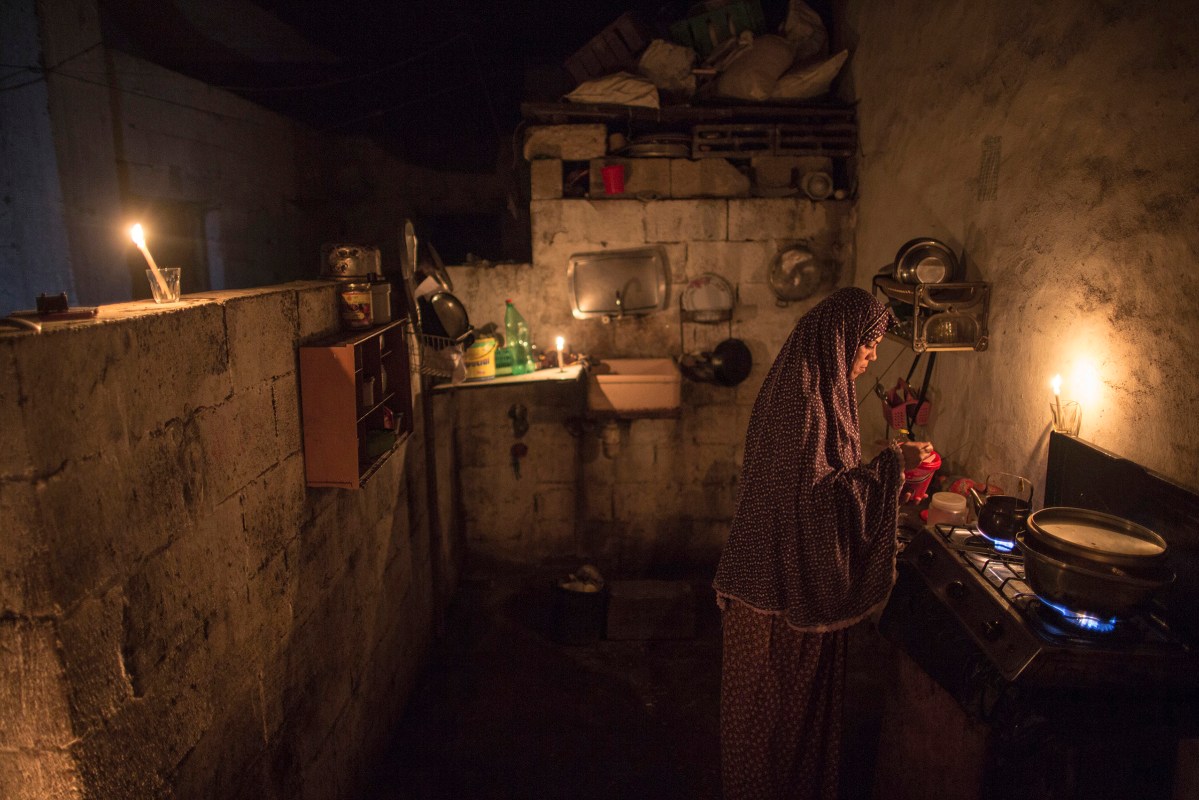 Eman Darabi 32, cooks food in the kitchen for her children in Beit lahyia northern gaza strip on on September 14, 2015 during a power outage. Residents of Gaza, home to 1.8 million people, have been experiencing up to 15 hours of electricity outage a day for the past two weeks due to fuel and power shortages.