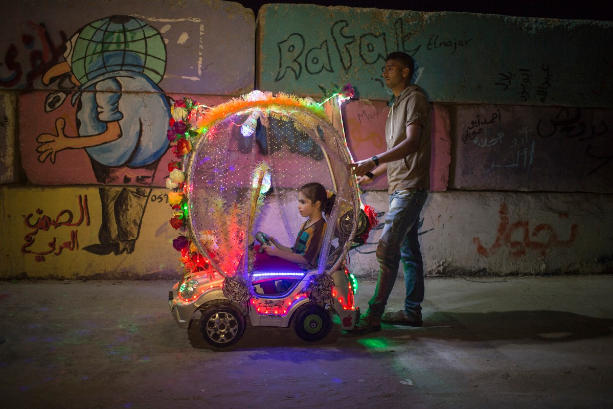 A Palestinian child riding in a colourful electric cart in Gaza port on June 1, 2015.