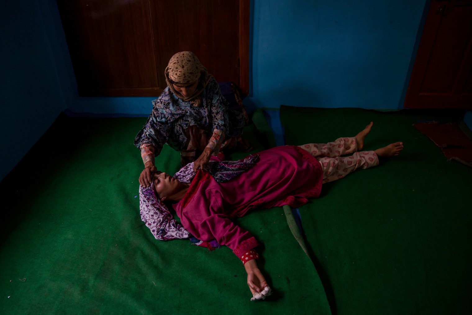 A woman tends to an unconscious relative of Kashmiri rebel Abid Hamid Mir during his funeral in Hajin, north of Srinagar, on Aug. 5, 2017.