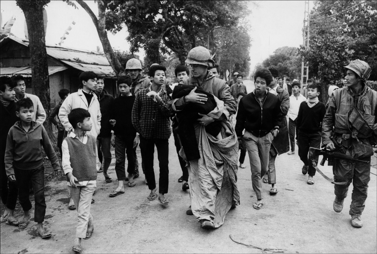 A wounded child caught in the crossfire during the Tet offensive being taken from the front by an army medic, Hue, Vietnam, 1968. 1998 © Don McCULLIN (CONTACT PRESS IMAGES)
