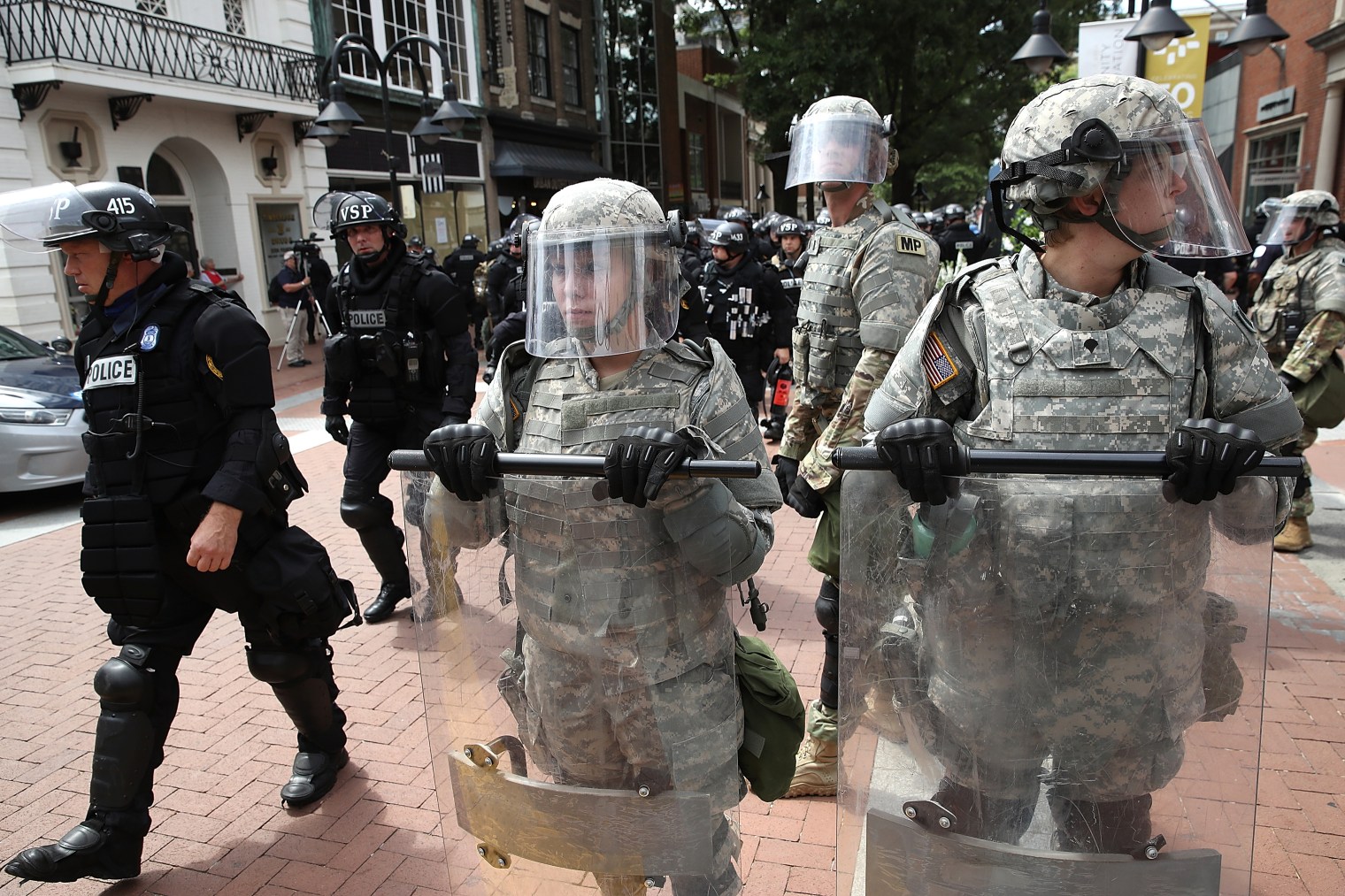 Police and members of the National Guard patrol near the location where a car plowed into a crowd of people marching through a downtown shopping district in Charlottesville, Va., on Aug. 12, 2017.