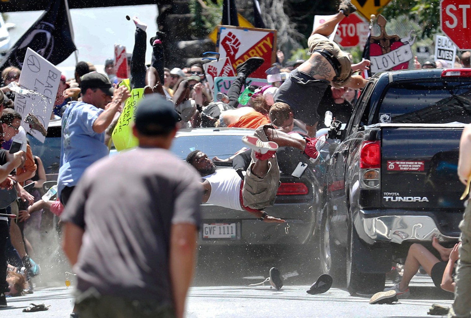 People fly into the air as a vehicle drives into a group of protesters demonstrating against a white nationalist rally