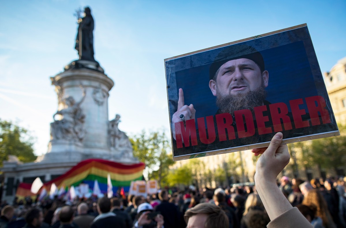 A demonstrator holders a sign depicting Chechen leader Ramzan Kadyrov with the label 