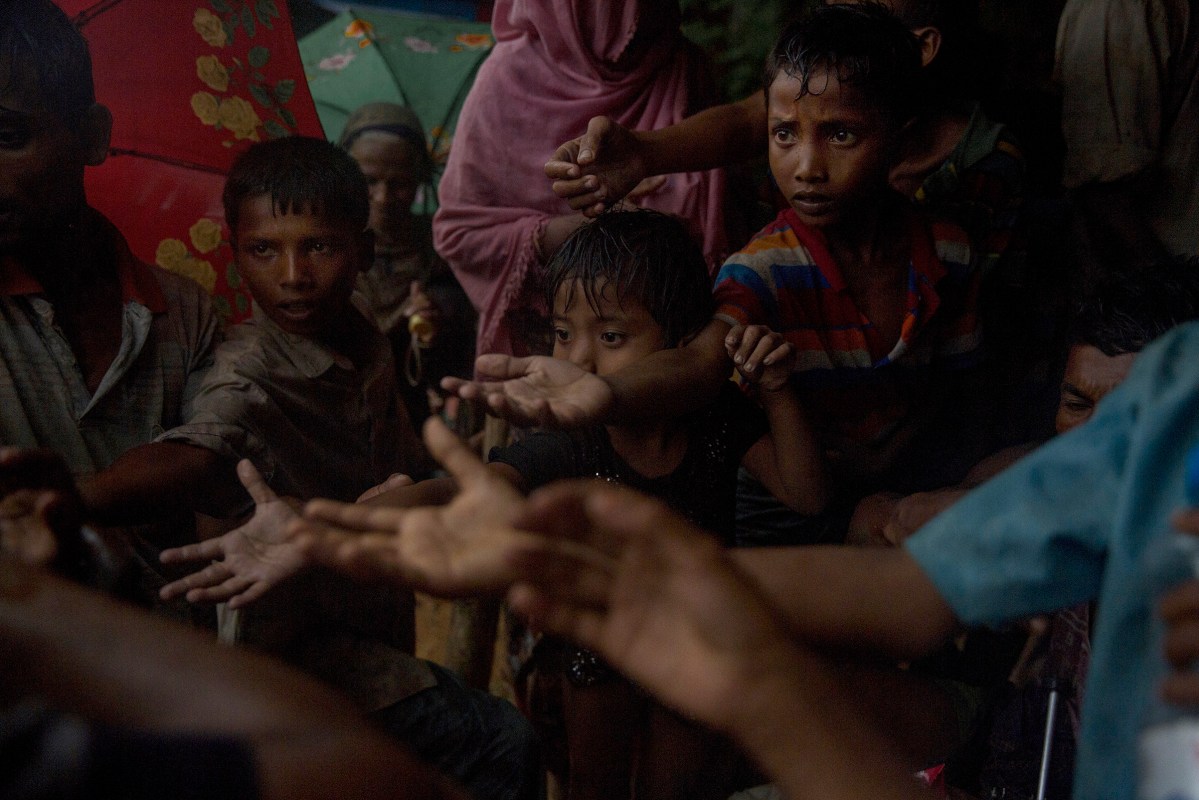 A local is distributing biscuits to Rohingya refugees children in Kutupalong station.The United Nations says 87,000 mostly Rohingya refugees have poured over the border into Bangladesh since the latest round of fighting broke out 10 days ago in Myanmar's neighbouring Rakhine state.The Rohingya are a mainly Muslim stateless ethnic minority who according to rights groups have faced decades of persecution in mainly Buddhist Myanmar. Bangladesh was already home to around 400,000 Rohingya before the current crisis. Figures on Sept 5th, 2017.