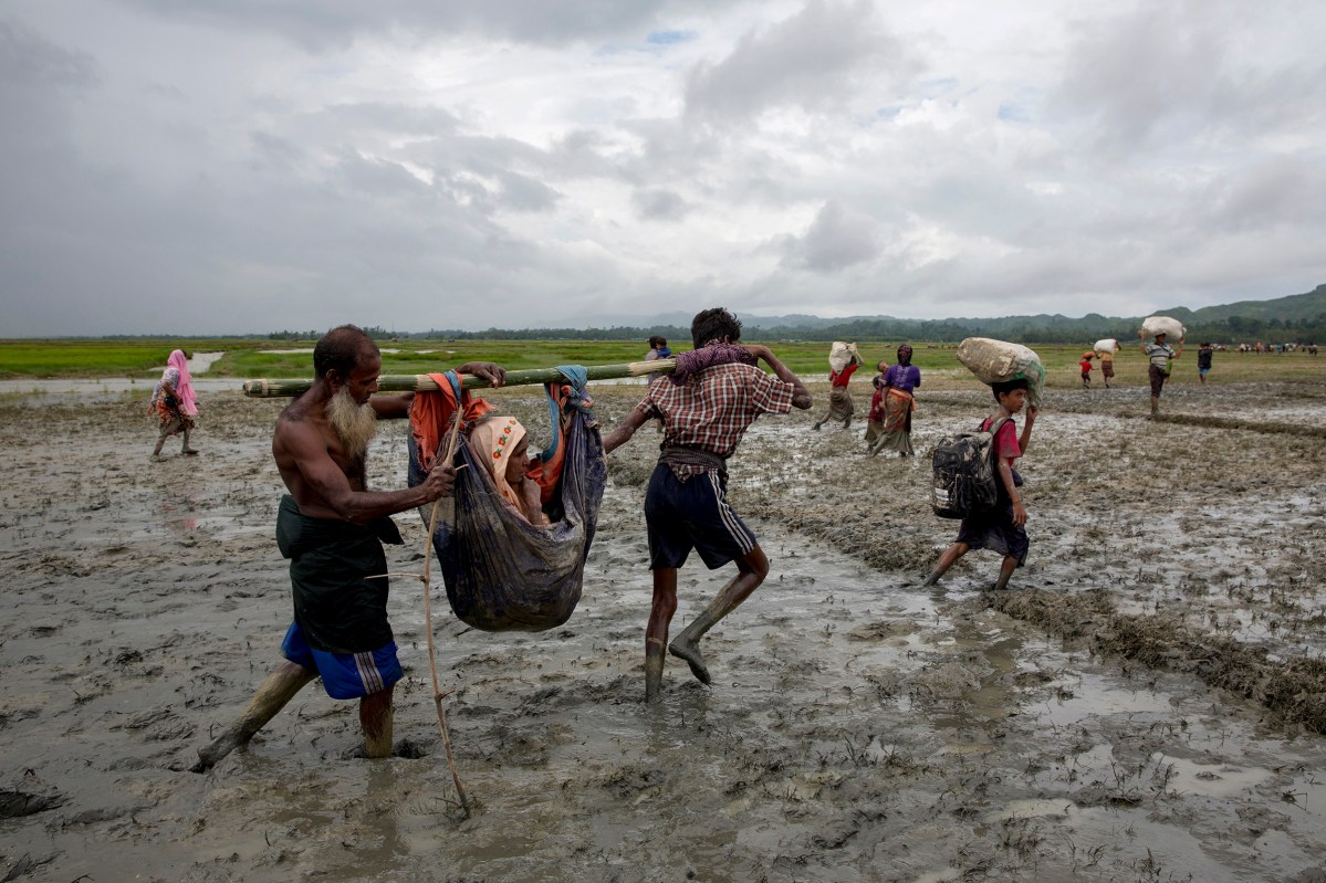 Rohingya refugees carry an elderly woman after crossing the border into Bangladesh, August 31, 2017.