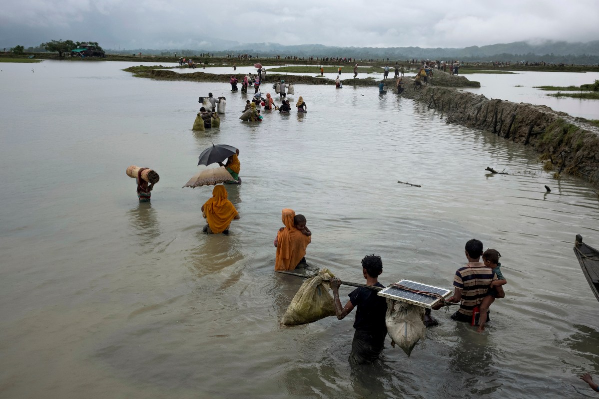 Members of Myanmar's Rohingya ethnic minority walk in flooded land after crossing the border into Bangladesh, September 1, 2017.
