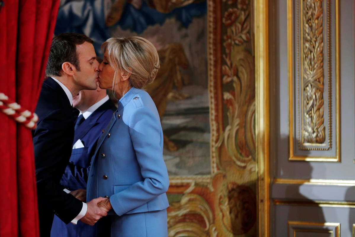 French President Emmanuel Macron kisses his wife Brigitte Trogneux during the handover ceremony in Paris