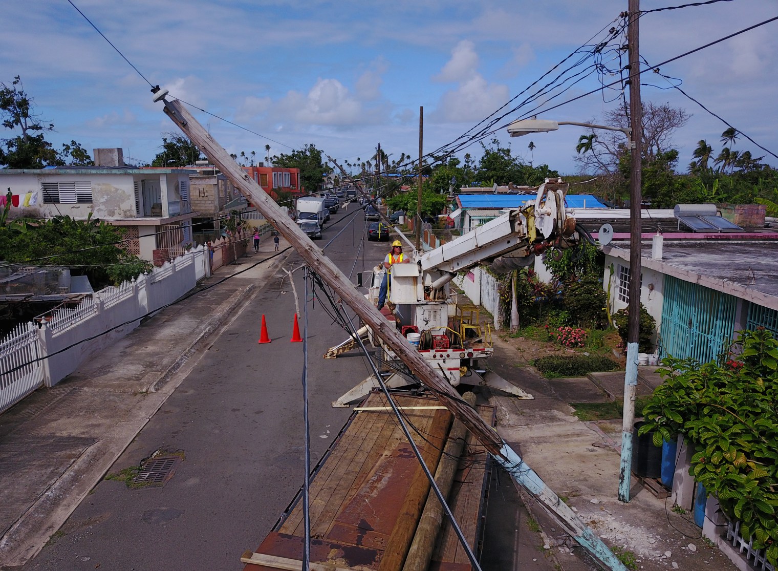 Utility workers replace a power pole in Loiza