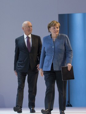 Klaus Schwab and German Chancellor Angela Merkel arrive for a plenary session at last yearâs WEF in Davos